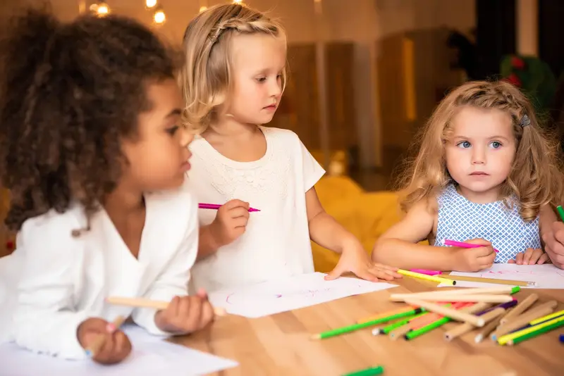 Children drawing together with felt tip pens at a nursery table Nursery Rhymes Broughty Ferry