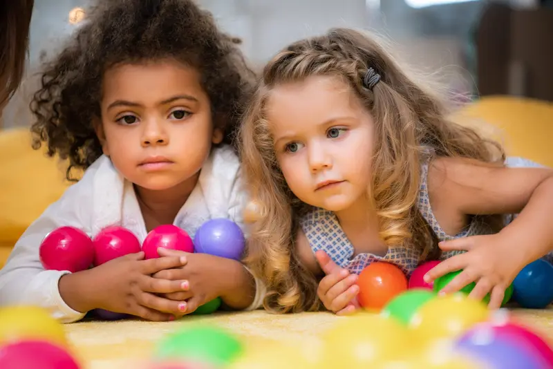 Two young children playing with soft coloured balls Nursery Rhymes nursery Dundee
