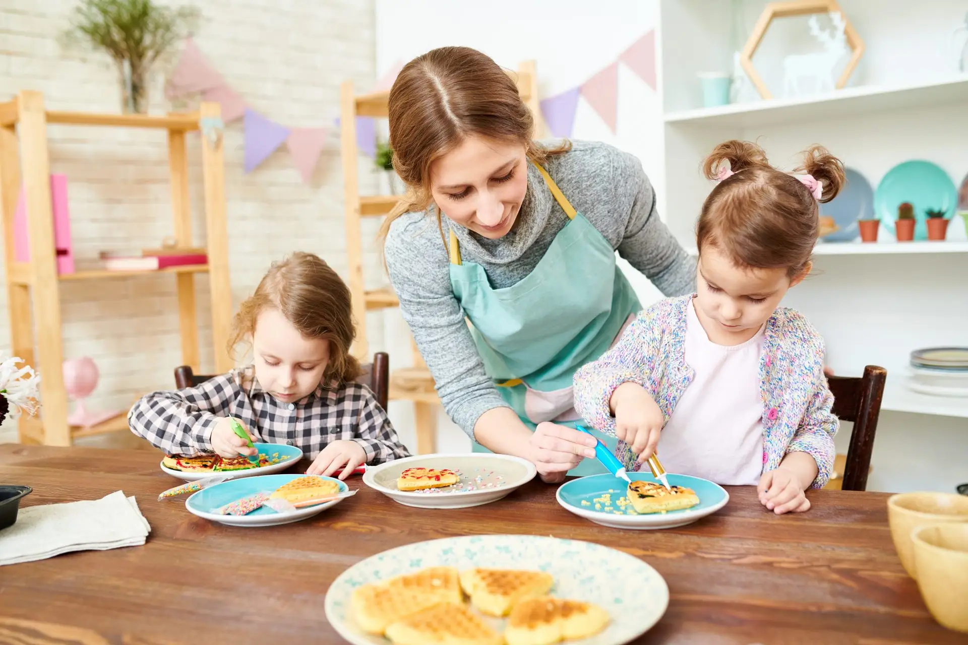 Nursery practitioner baking with young children at a table Nursery Rhymes Broughty Ferry