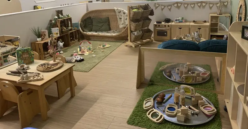 Natural wooden toys, soft seating and play trays in the playroom at Nursery Rhymes Broughty Ferry