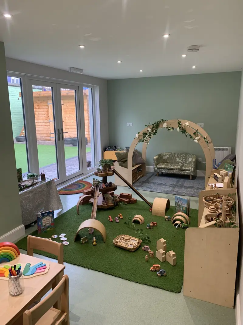 Calm baby and toddler room with play arch and garden doors at Nursery Rhymes Broughty Ferry